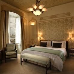 "Elegant, high-ceiling guest room with Art Deco furniture and plush decor at Casa Gangotena, Quito."